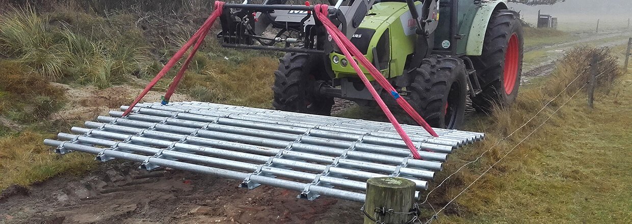 En traktor flyttar en frist frn en plats till en annan. Denna flyttbara frist kan bara anvndas av terrngfordon | Poda Stngsel